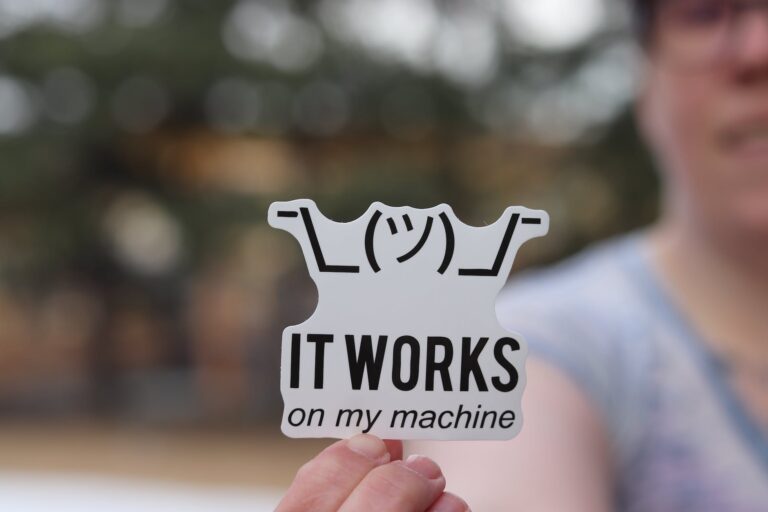 man holding a sticker with a programming meme